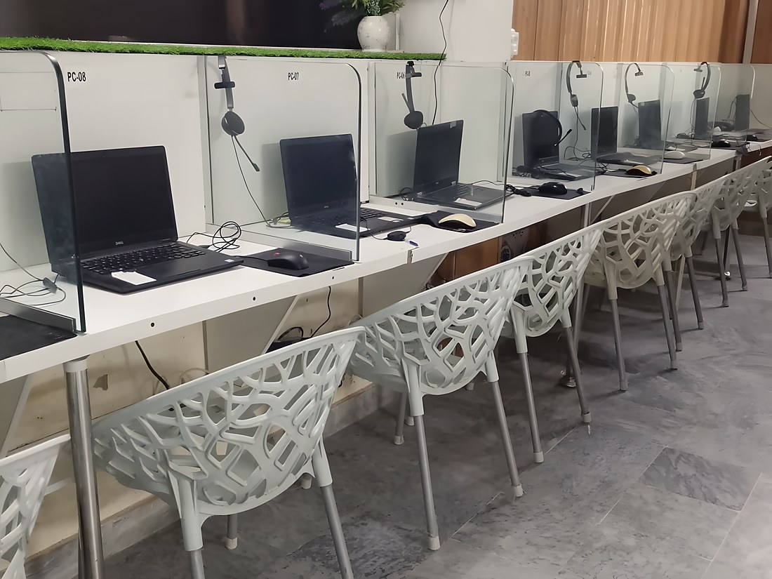 The teaching room empty, a row of numbered stations each with its own headset