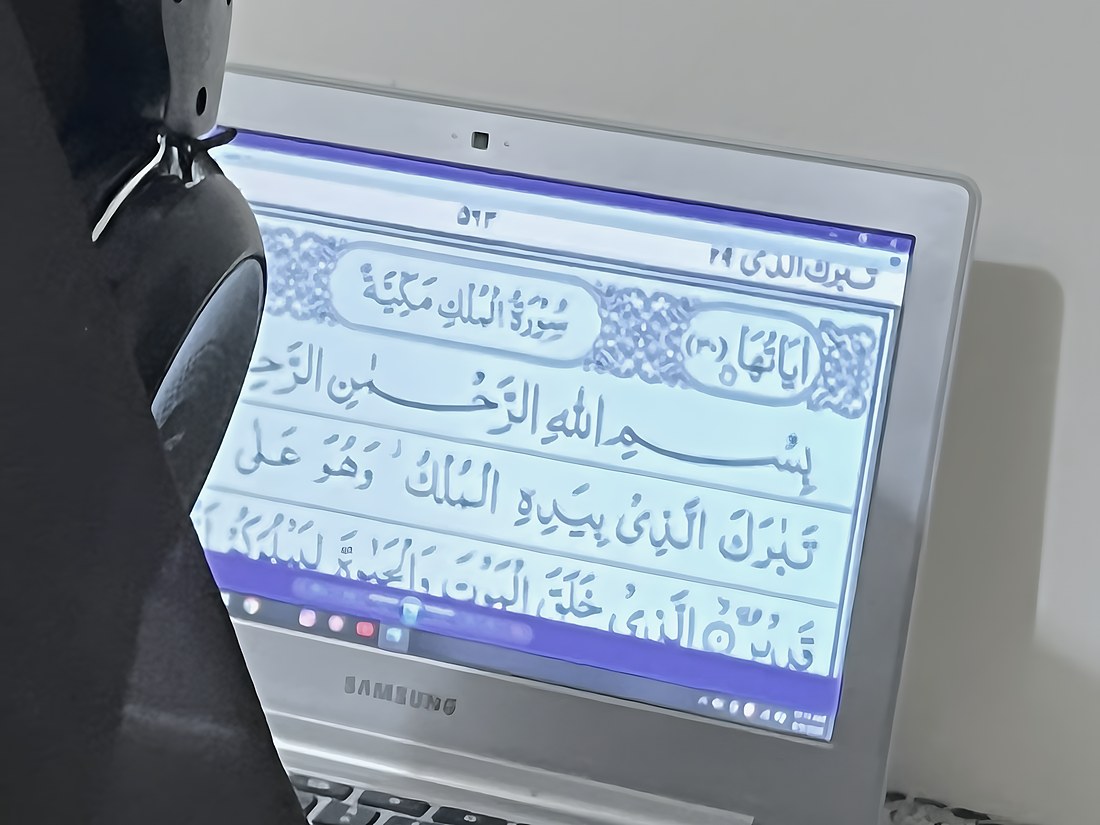 A page of Surah Al-Mulk open on a laptop screen